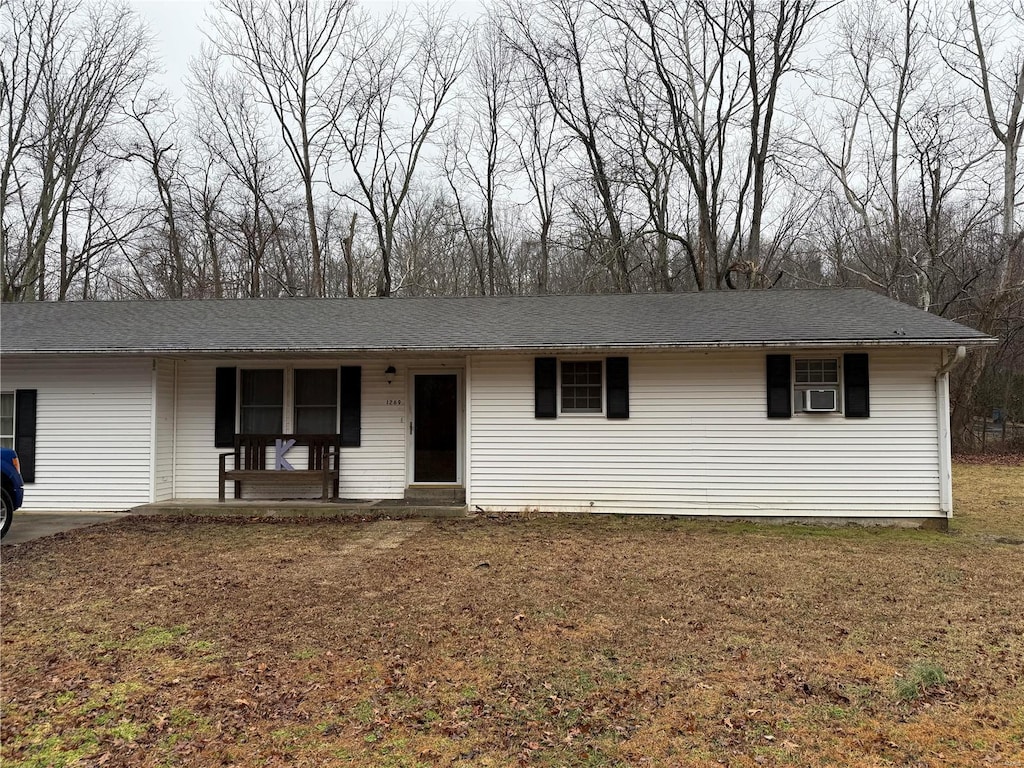 ranch-style house with cooling unit and a front lawn