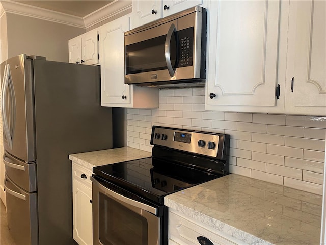 kitchen featuring decorative backsplash, ornamental molding, stainless steel appliances, light countertops, and white cabinetry