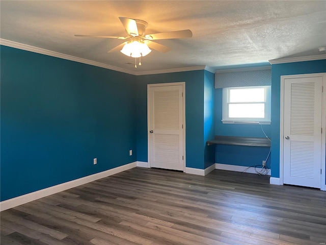 unfurnished bedroom featuring ornamental molding, dark wood-type flooring, ceiling fan, a textured ceiling, and baseboards