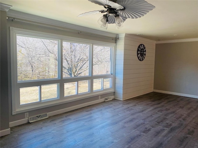 spare room with baseboards, ornamental molding, and visible vents