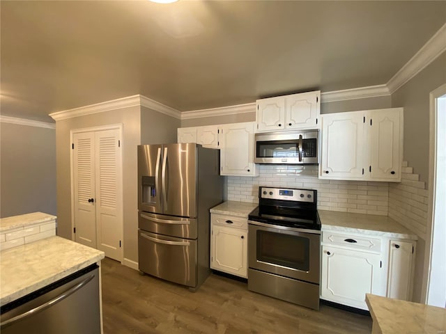 kitchen with crown molding, dark wood-style flooring, light countertops, white cabinetry, and appliances with stainless steel finishes