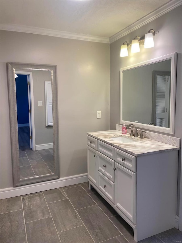 bathroom featuring vanity, ornamental molding, baseboards, and tile patterned flooring