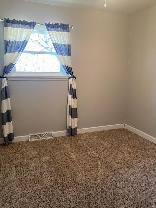 carpeted empty room with baseboards and visible vents