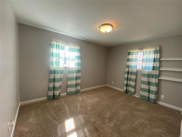 spare room with baseboards and carpet flooring