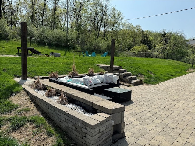 view of home's community with a patio, a lawn, fence, and an outdoor hangout area