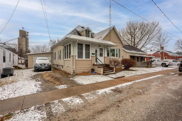 bungalow-style house featuring a garage and central AC