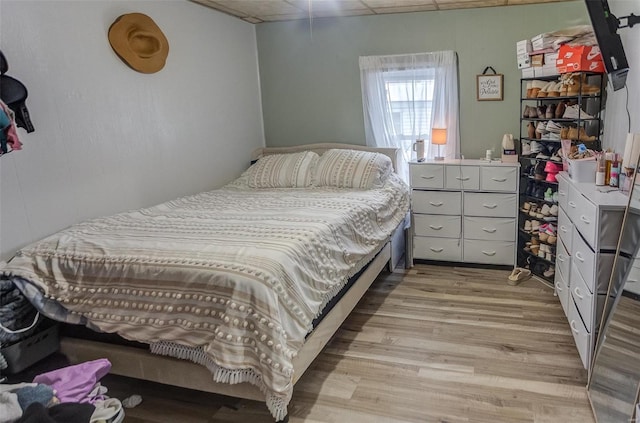 bedroom featuring a paneled ceiling and light hardwood / wood-style floors