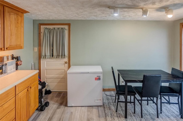 interior space with a textured ceiling and light wood-type flooring