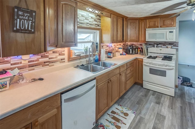 kitchen with sink, tasteful backsplash, ceiling fan, hardwood / wood-style flooring, and white appliances