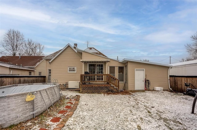 rear view of house featuring a swimming pool side deck