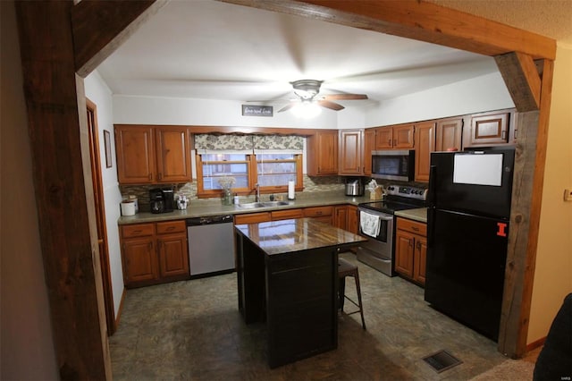 kitchen with sink, a breakfast bar area, backsplash, stainless steel appliances, and a kitchen island