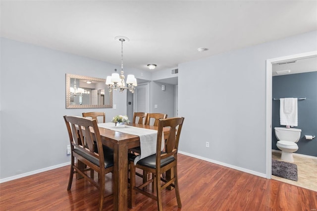 dining space featuring a notable chandelier and dark hardwood / wood-style flooring