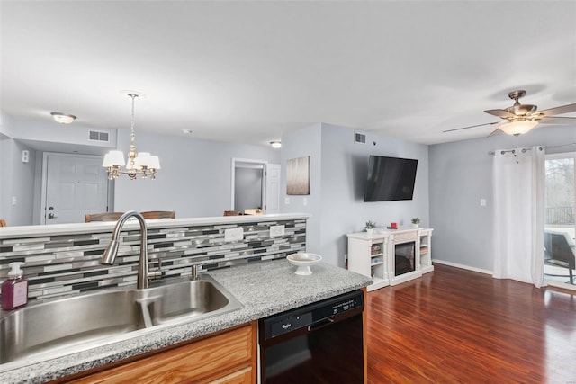 kitchen with decorative light fixtures, black dishwasher, sink, decorative backsplash, and dark wood-type flooring