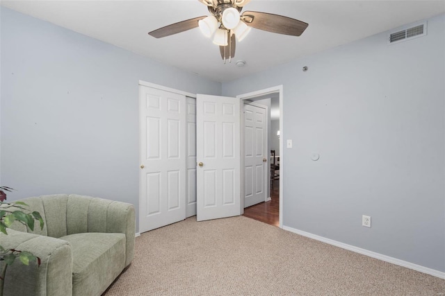 living area featuring ceiling fan and carpet flooring