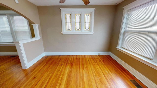 unfurnished room with light wood-style floors, visible vents, and baseboards