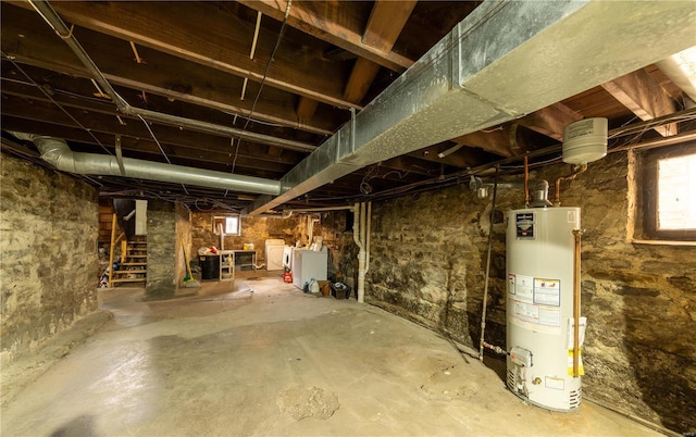 basement with water heater, stairway, and washer and clothes dryer