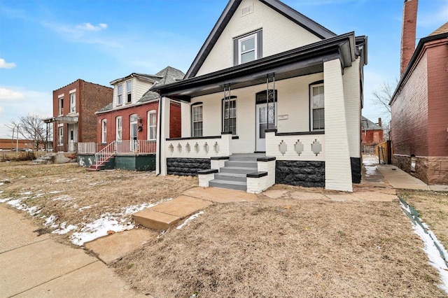 view of front of house with covered porch and brick siding