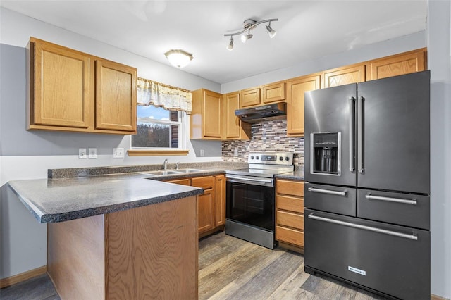 kitchen featuring sink, tasteful backsplash, dark hardwood / wood-style flooring, kitchen peninsula, and stainless steel appliances