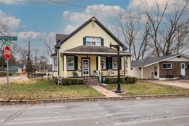 bungalow-style house with a front yard and covered porch