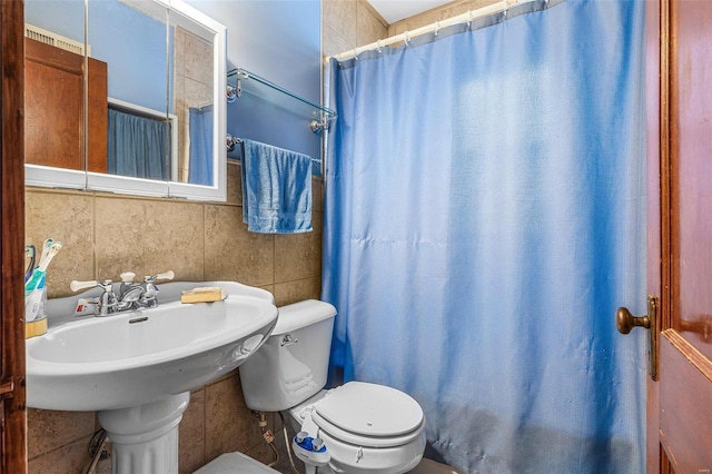 bathroom featuring toilet, tile walls, and a shower with curtain