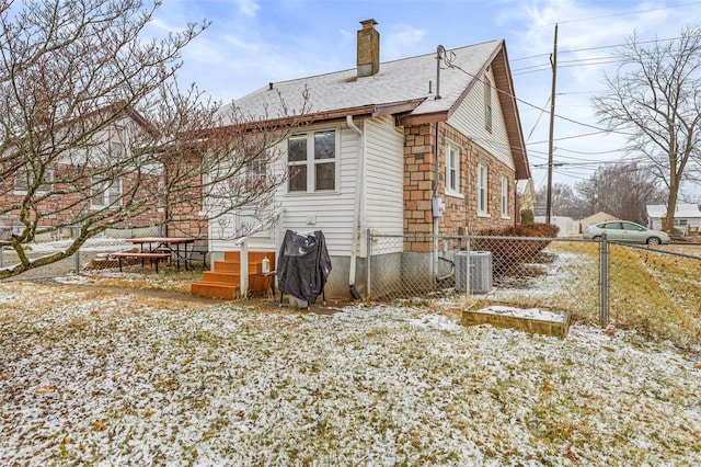 snow covered back of property with central air condition unit