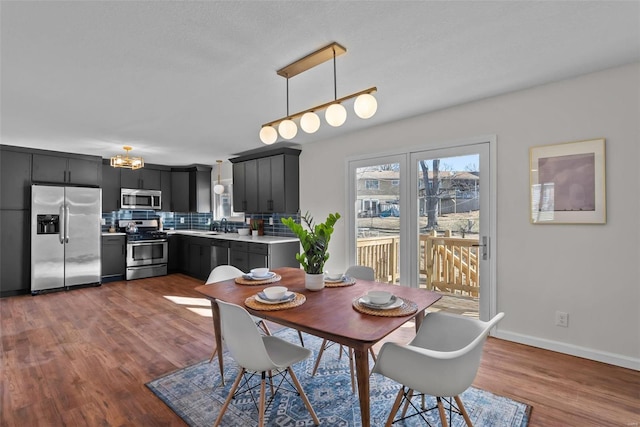 dining room with baseboards and dark wood-type flooring