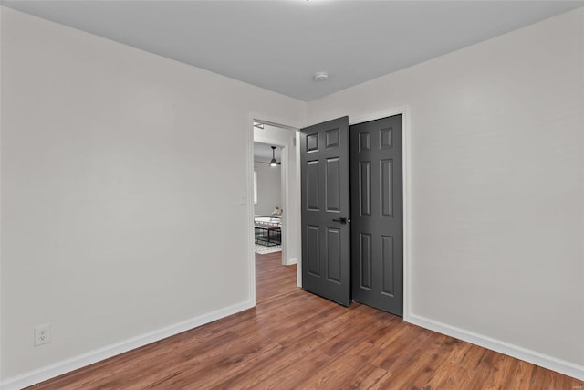 empty room featuring wood finished floors and baseboards