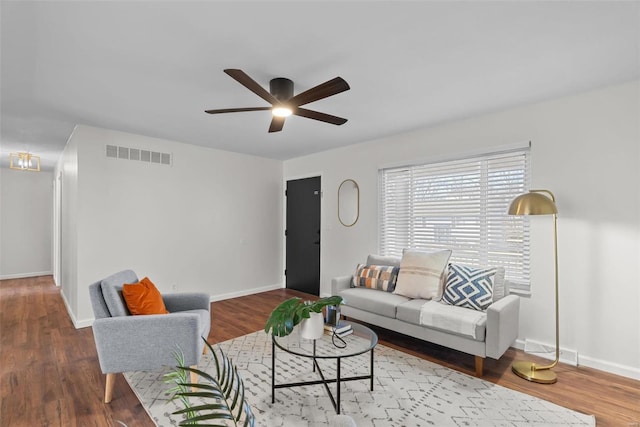 living area with visible vents, baseboards, and wood finished floors