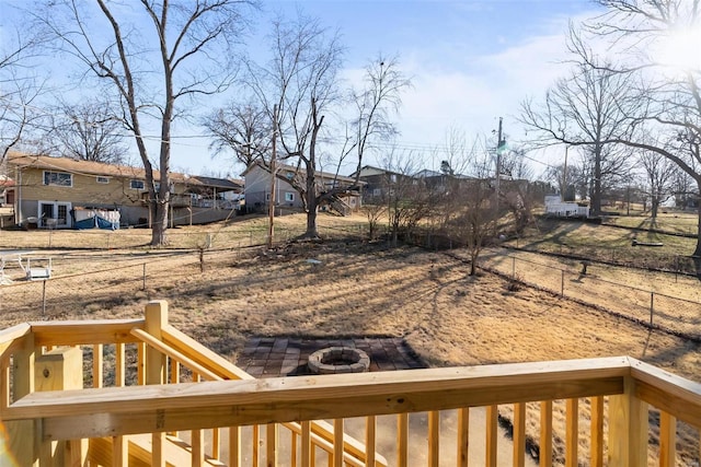 view of yard with fence, a fire pit, and a residential view