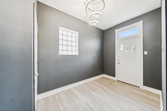 foyer with a chandelier and light hardwood / wood-style flooring