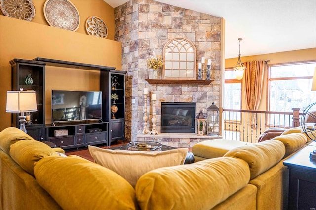 living room with lofted ceiling and a stone fireplace