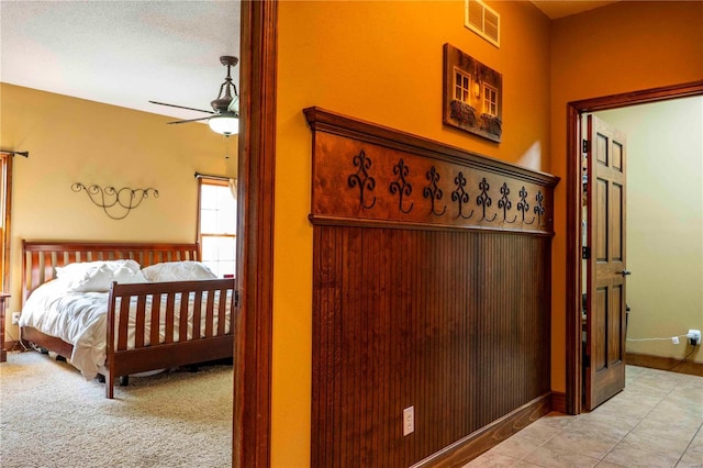 tiled bedroom featuring ceiling fan