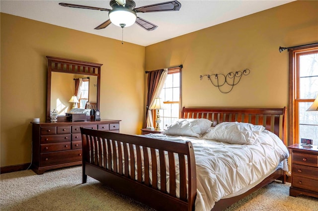 carpeted bedroom featuring multiple windows and ceiling fan