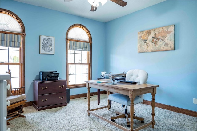 carpeted home office featuring ceiling fan