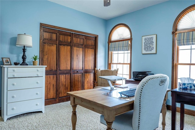 carpeted office space with ceiling fan