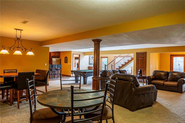 carpeted living room featuring pool table, decorative columns, and a textured ceiling