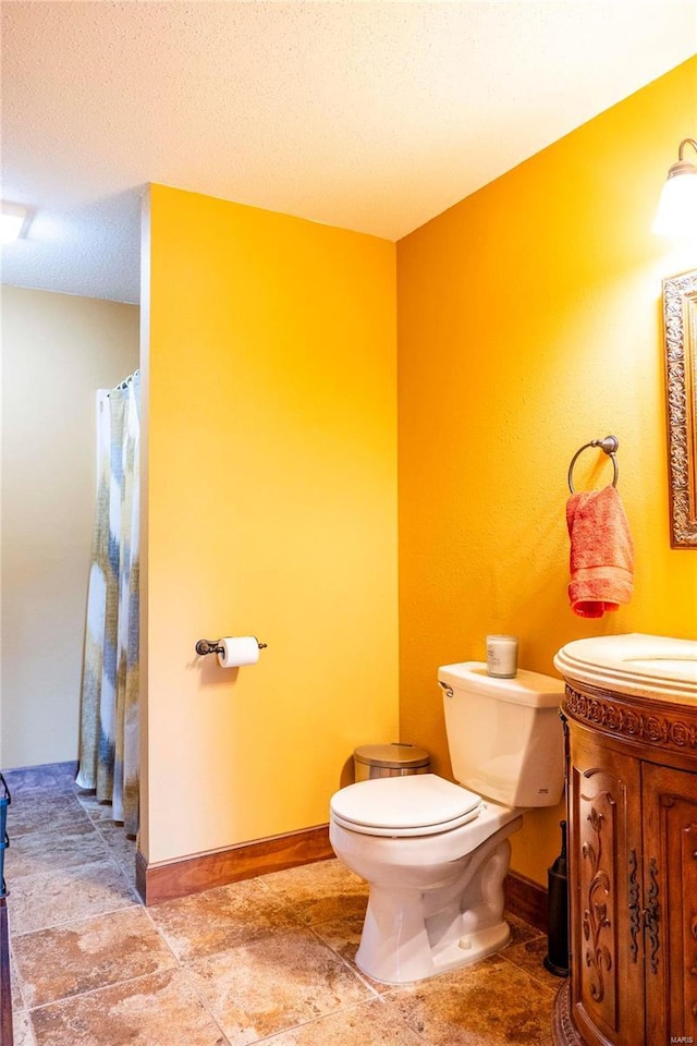 bathroom with vanity, a textured ceiling, and toilet