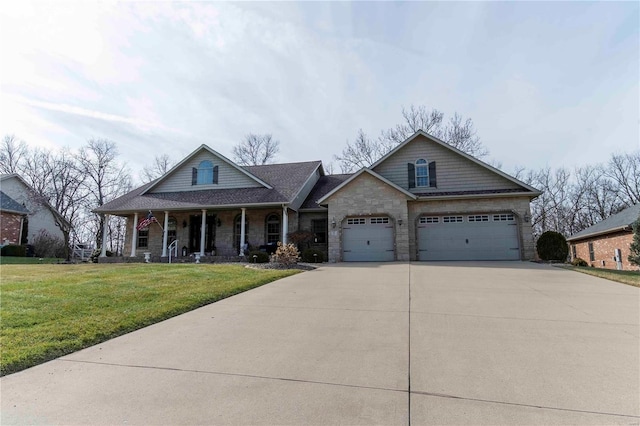 view of front of property with a garage, covered porch, and a front yard