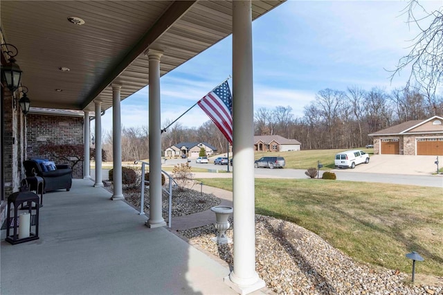 view of patio with an outbuilding, a garage, and covered porch