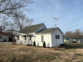 back of house with a yard and covered porch