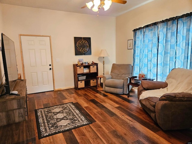 living room featuring dark wood-type flooring and ceiling fan