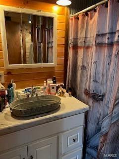 bathroom with vanity and wooden walls