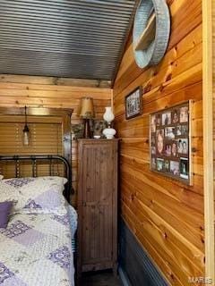 bedroom with mail boxes and wood walls