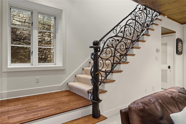 stairs featuring wood ceiling and baseboards