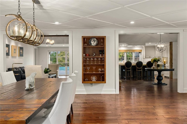 dining space featuring dark wood-style floors, plenty of natural light, and a notable chandelier