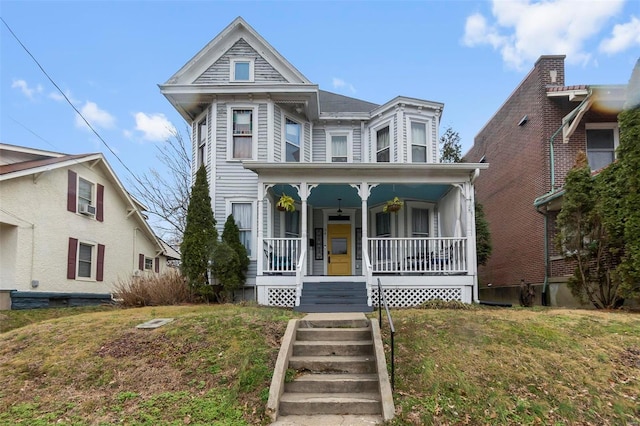 victorian home featuring a front lawn and a porch