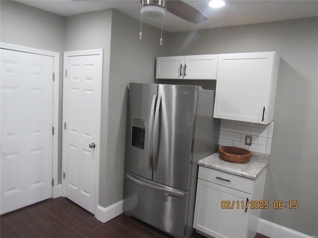 kitchen with stainless steel refrigerator with ice dispenser, tasteful backsplash, dark hardwood / wood-style flooring, ceiling fan, and white cabinets