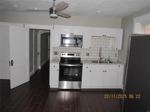 kitchen with sink, dark wood-type flooring, stainless steel appliances, and white cabinets