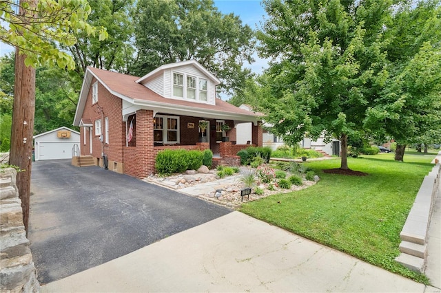 bungalow with brick siding, a front lawn, an outdoor structure, and a detached garage