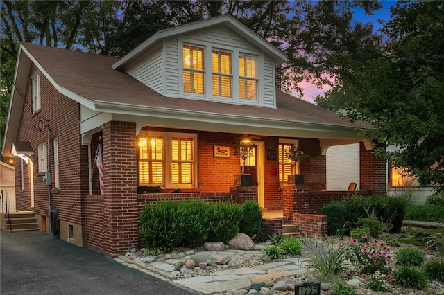 view of front of home featuring a porch and brick siding